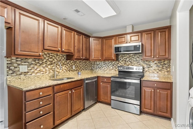 kitchen with tasteful backsplash, sink, light tile patterned floors, and appliances with stainless steel finishes