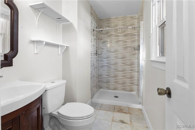 bathroom featuring vanity, toilet, and a tile shower