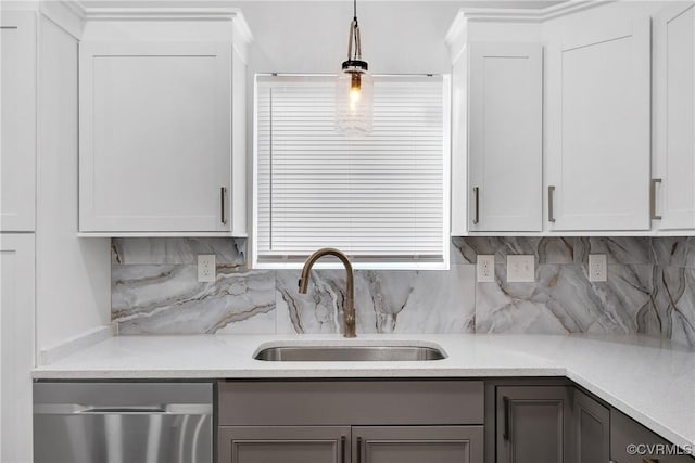 kitchen with sink, dishwasher, white cabinets, and pendant lighting