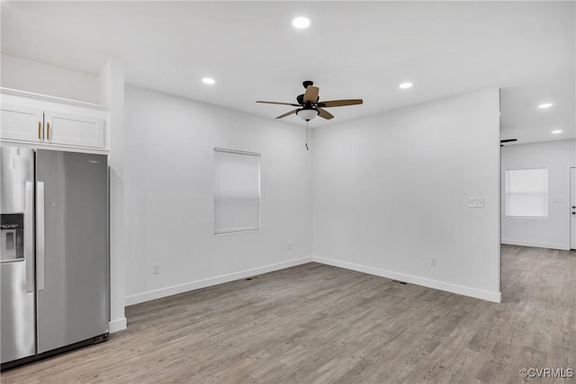 kitchen with white cabinets, stainless steel fridge, light hardwood / wood-style floors, and ceiling fan