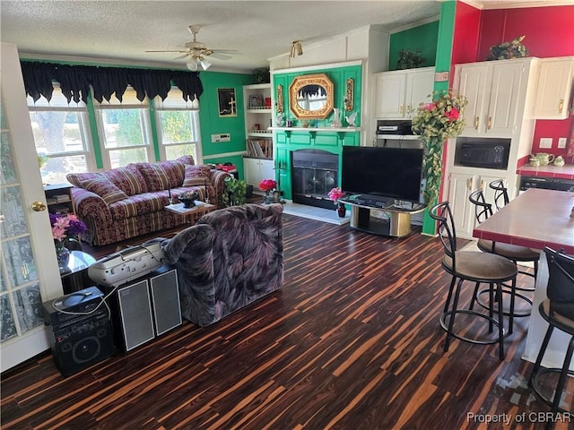 living room featuring ceiling fan, lofted ceiling, ornamental molding, and a textured ceiling