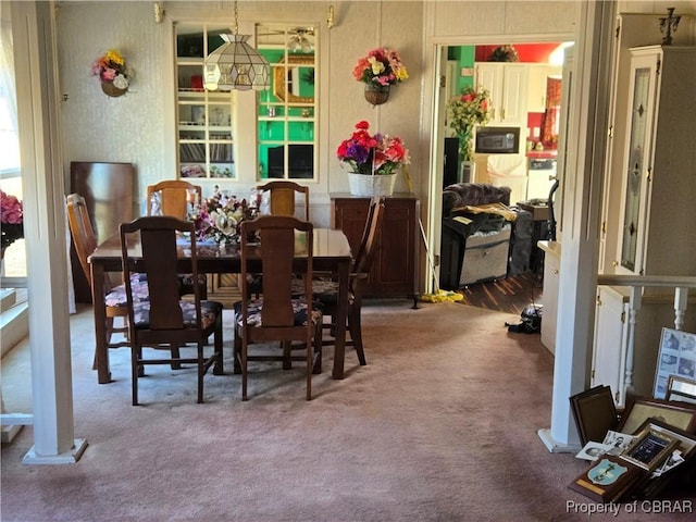 dining space with carpet and an inviting chandelier