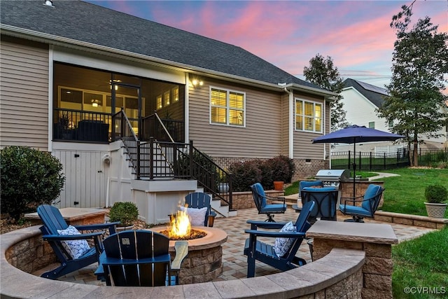 patio terrace at dusk featuring a grill and a fire pit