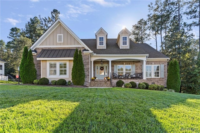 view of front of house with covered porch and a front lawn