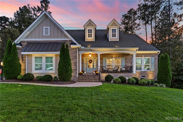 view of front of home featuring a lawn and covered porch