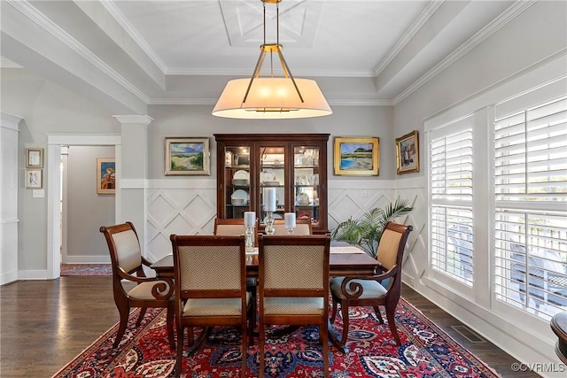 dining space featuring crown molding, dark wood-type flooring, and decorative columns