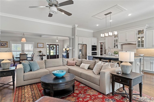 living room featuring sink, crown molding, ceiling fan, and hardwood / wood-style flooring