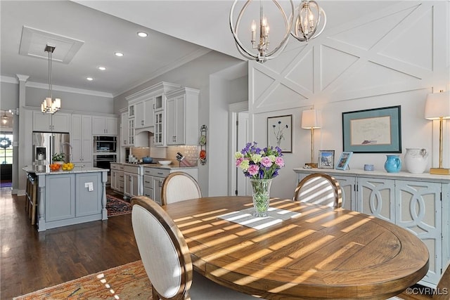 dining room with ornamental molding, dark hardwood / wood-style floors, and a chandelier