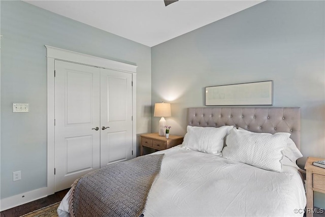 bedroom with dark hardwood / wood-style flooring and a closet