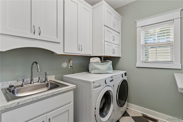 laundry area with sink, washing machine and dryer, and cabinets