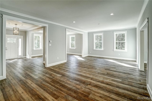 unfurnished living room featuring ornamental molding and dark wood-type flooring