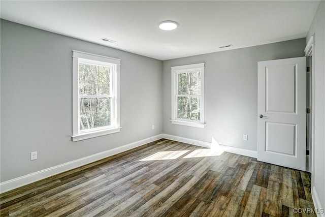 empty room with plenty of natural light and wood-type flooring