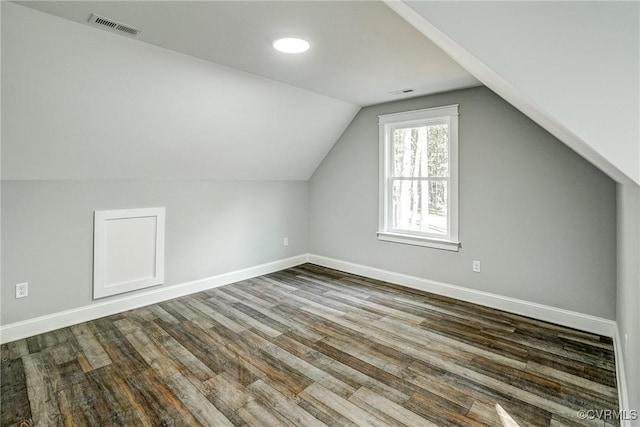 additional living space with hardwood / wood-style floors and lofted ceiling