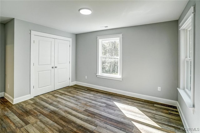 unfurnished bedroom with hardwood / wood-style flooring and a closet