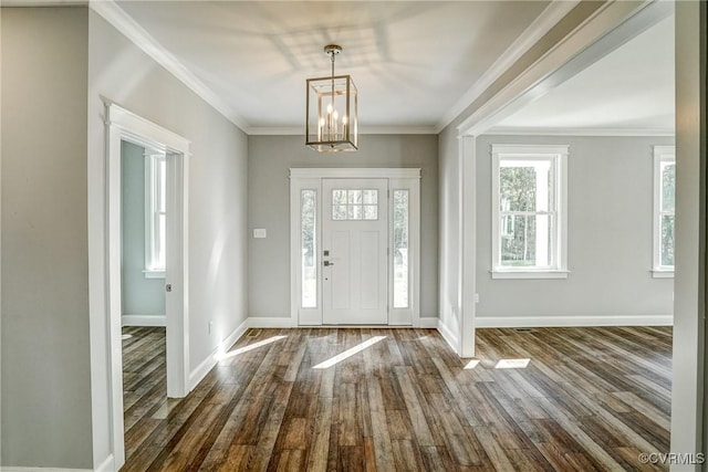 entrance foyer with an inviting chandelier, ornamental molding, and dark hardwood / wood-style floors