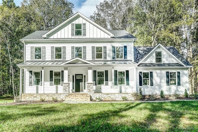 modern inspired farmhouse featuring covered porch and a front yard