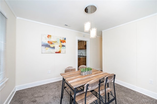 carpeted dining room featuring sink and ornamental molding