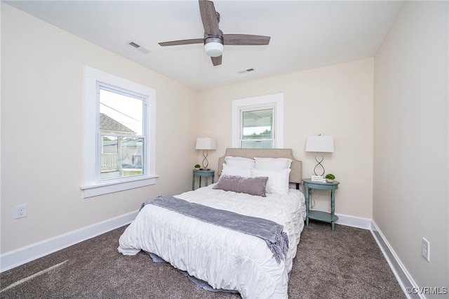 carpeted bedroom with ceiling fan and multiple windows