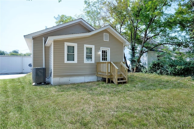 back of house with a lawn and central AC unit