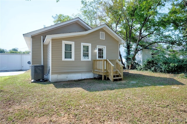 rear view of house featuring a yard and central AC