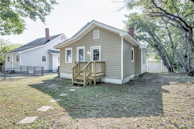 rear view of property featuring a yard