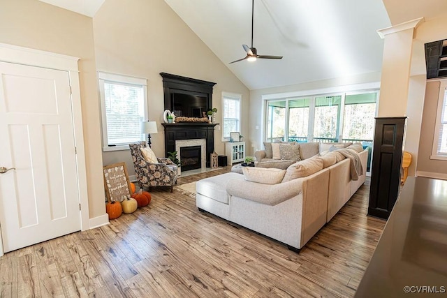 living room with ceiling fan, high vaulted ceiling, light hardwood / wood-style flooring, and plenty of natural light