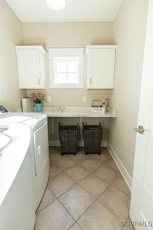 clothes washing area featuring light tile patterned flooring, cabinets, and independent washer and dryer