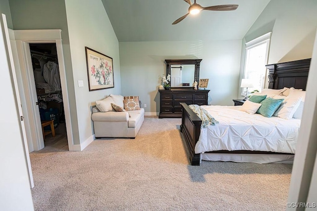 carpeted bedroom featuring ceiling fan, a closet, a walk in closet, and vaulted ceiling