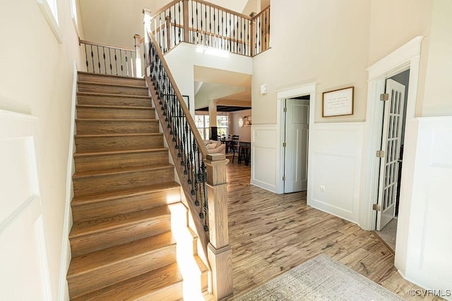 stairway featuring a high ceiling and hardwood / wood-style floors