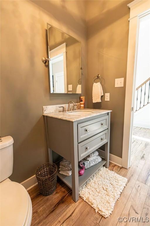 bathroom with hardwood / wood-style floors, toilet, and vanity