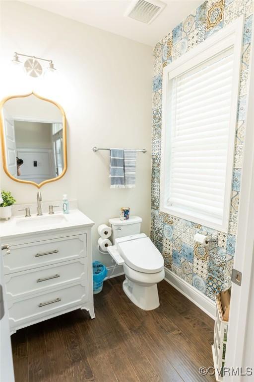 bathroom with hardwood / wood-style flooring, toilet, and vanity