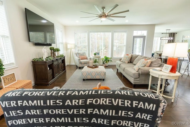 living room featuring ceiling fan, dark wood-type flooring, and a wealth of natural light