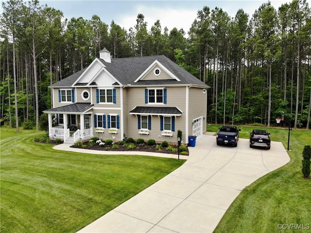 view of front of home featuring a garage, a front yard, and a porch