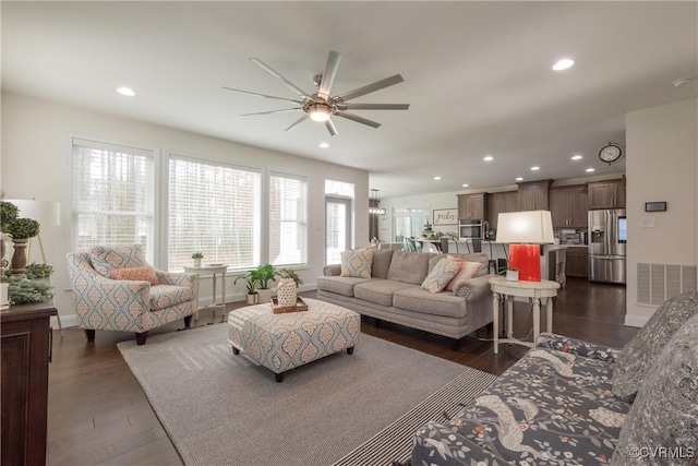 living room featuring dark wood-type flooring and ceiling fan