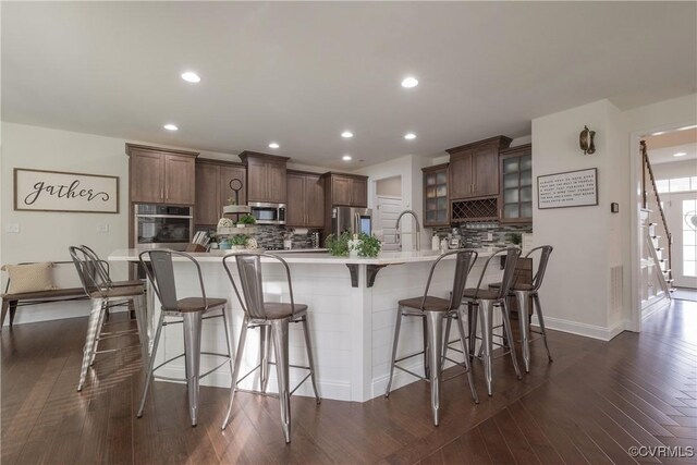 12618 Capernwray Ter, Chesterfield, VA 23838 - kitchen featuring stainless steel appliances, a kitchen bar, tasteful backsplash, glass insert cabinets, and recessed lighting