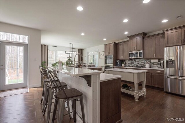 12618 Capernwray Ter, Chesterfield, VA 23838 - kitchen featuring appliances with stainless steel finishes, a spacious island, dark wood finished floors, backsplash, and light countertops