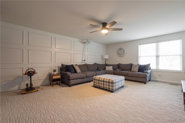 carpeted living room with ceiling fan