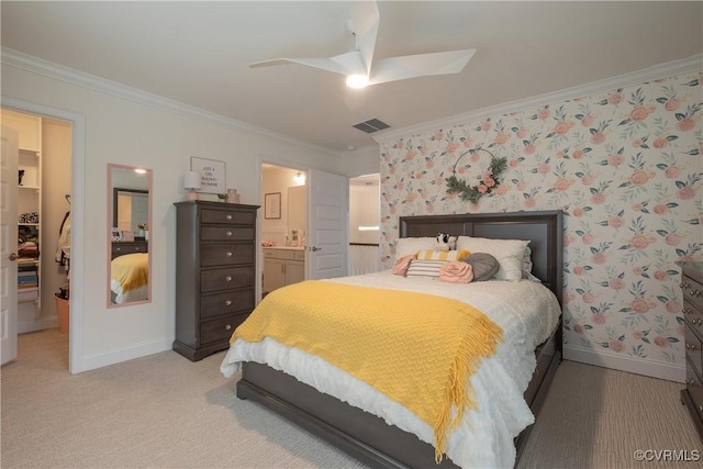 bedroom featuring crown molding, ensuite bath, ceiling fan, a spacious closet, and light colored carpet