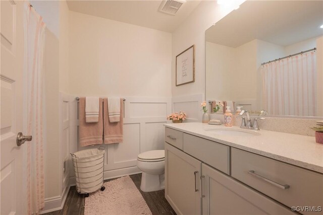 12618 Capernwray Ter, Chesterfield, VA 23838 - bathroom with wood finished floors, vanity, toilet, wainscoting, and a decorative wall