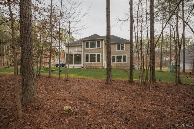 rear view of property featuring a sunroom and a yard