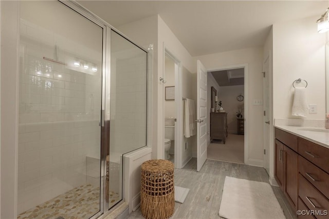 bathroom featuring vanity, wood-type flooring, walk in shower, and toilet