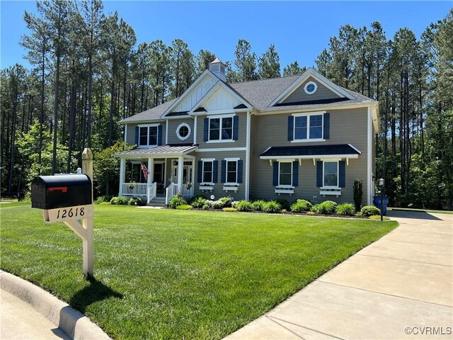 12618 Capernwray Ter, Chesterfield, VA 23838 - view of front facade with covered porch, a front lawn, and a chimney