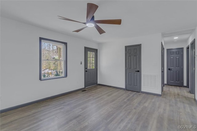 empty room with ceiling fan and light hardwood / wood-style flooring