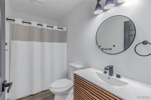 bathroom with toilet, vanity, and hardwood / wood-style floors