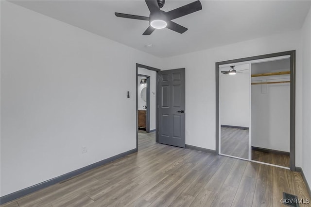 unfurnished bedroom featuring ceiling fan, hardwood / wood-style floors, and a closet