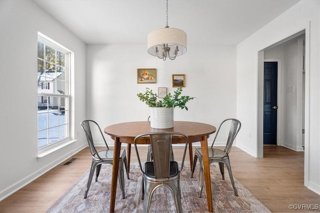 dining space featuring an inviting chandelier and hardwood / wood-style floors