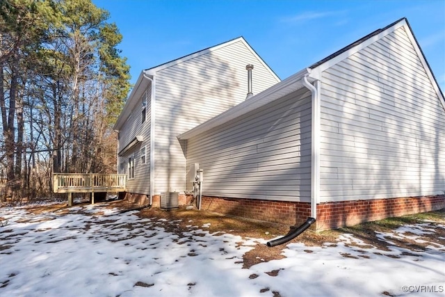 view of snow covered exterior featuring cooling unit and a wooden deck