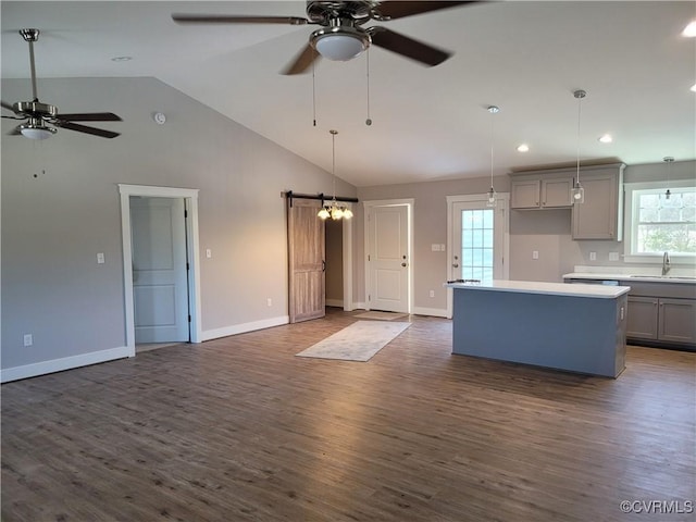 kitchen featuring gray cabinets, dark hardwood / wood-style flooring, a kitchen island, decorative light fixtures, and ceiling fan with notable chandelier