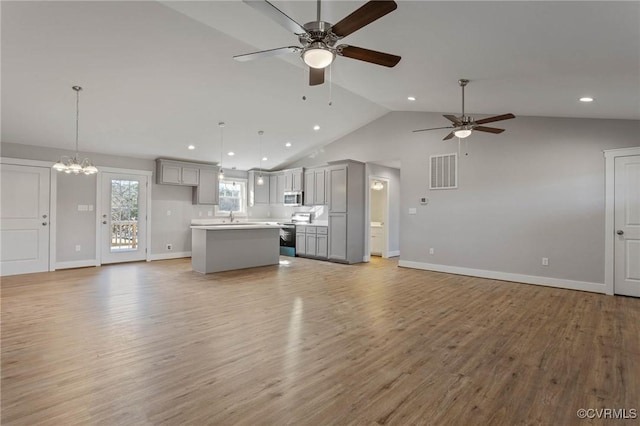 unfurnished living room featuring lofted ceiling, sink, ceiling fan with notable chandelier, and light hardwood / wood-style floors