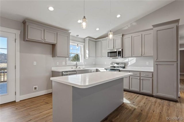 kitchen featuring pendant lighting, sink, gray cabinets, appliances with stainless steel finishes, and a kitchen island